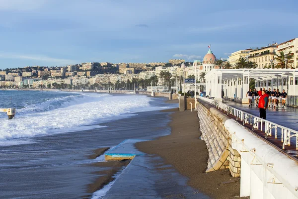 NICE, FRANCIA - el 8 de enero de 2016. Vista de la línea de surf, ola, playa y cielo y terraplén a distancia — Foto de Stock