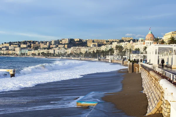 Nice, Frankrike - den 8 januari 2016. Visa av linjen en surfa, våg, beach och sky och vallen i distans — Stockfoto