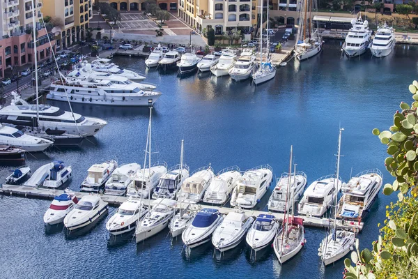 MONTE-CARLO, MONACO, on JANUARY 10, 2016. A view of houses on a slope of the mountain and the yacht at the mooring in a bay — Stock Photo, Image