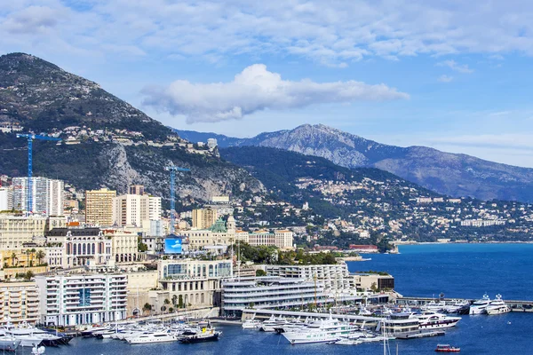 MONTE-CARLO, MONACO, on JANUARY 10, 2016. A view of houses on a slope of the mountain and the yacht at the mooring in a bay — Stock Photo, Image