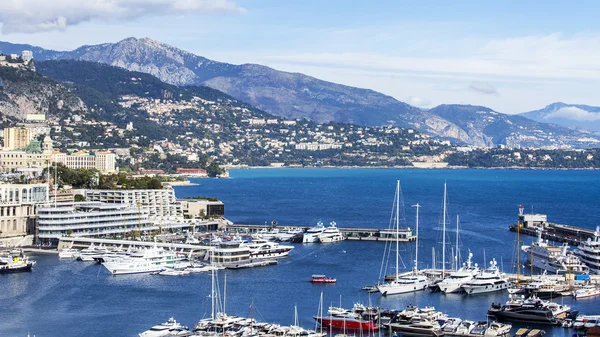 MONTE-CARLO, MONACO, em 10 de julho de 2016. Uma vista de casas em uma inclinação da montanha e o iate na amarração em uma baía — Fotografia de Stock