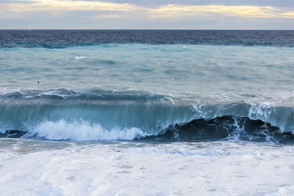 Θαλασσινό τοπίο. Τη γραμμή από μια κύματα surf και θύελλα ανάβει με τις ακτίνες του ήλιου ηλιοβασίλεμα. — Φωτογραφία Αρχείου