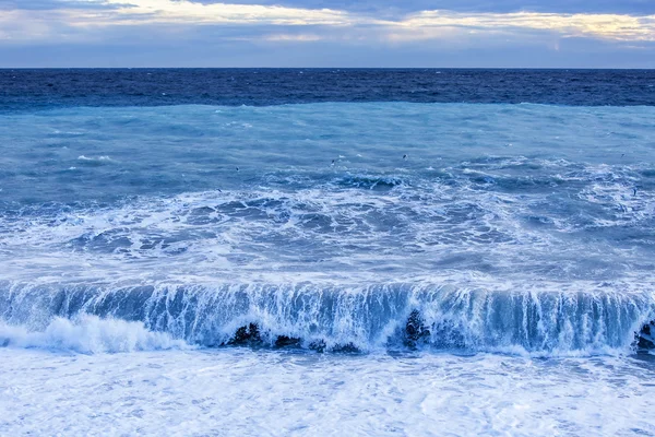 Θαλασσινό τοπίο. Τη γραμμή από μια κύματα surf και θύελλα ανάβει με τις ακτίνες του ήλιου ηλιοβασίλεμα — Φωτογραφία Αρχείου