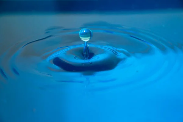 Niebieskie Krople Wody Uderzają Powierzchnię Wody — Zdjęcie stockowe