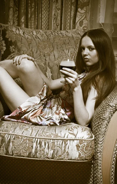 Sexig kvinna sitter på fåtölj hemma — Stockfoto