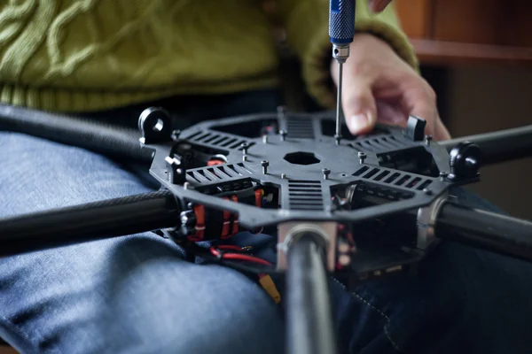 Mains d'homme assemblant multicopter — Photo