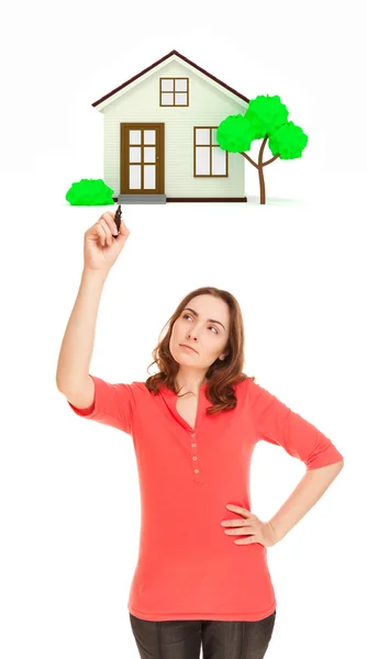 Thoughtful woman with marker drawing house — Stock Photo, Image