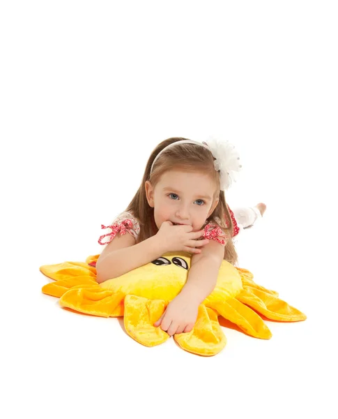 Little girl with toy lying on the floor isolated — Stock Photo, Image