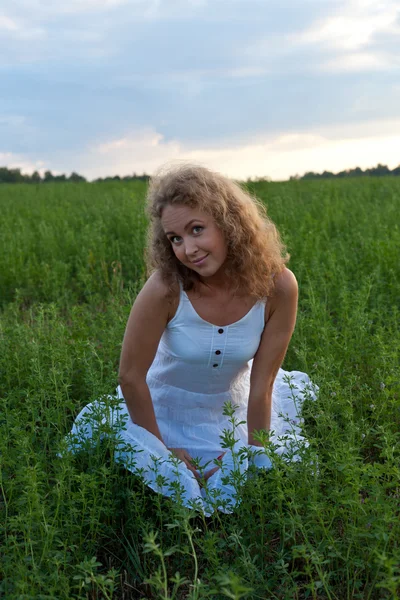 Foto van mooie vrouw zitten op gras — Stockfoto