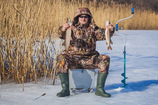 Pescador pegar lúcio na pesca de inverno — Fotografia de Stock