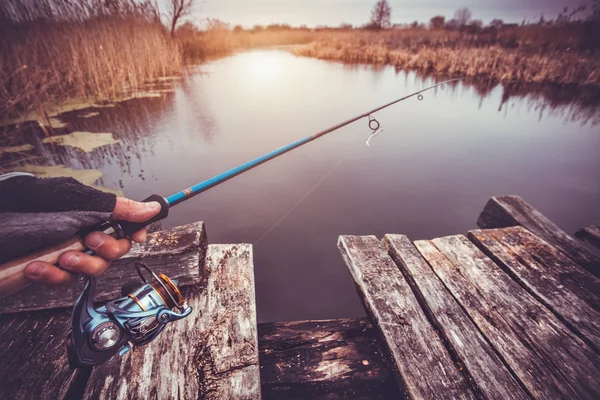 Hombre sosteniendo varilla giratoria en el río. pesca —  Fotos de Stock