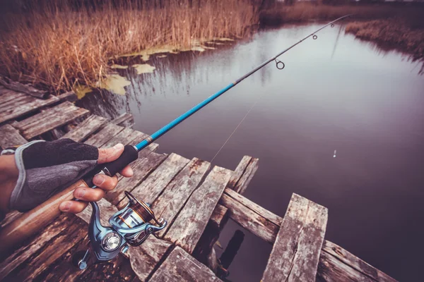 Man holding spinning rod on the river. fishing