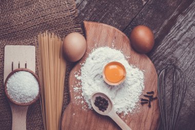 Makarna spagetti eski ahşap arka plan üzerine un, yumurta