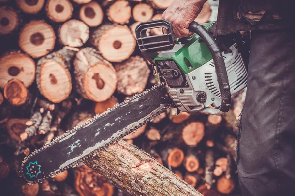 Male hands cutting trunk with chainsaw — Stock Photo, Image