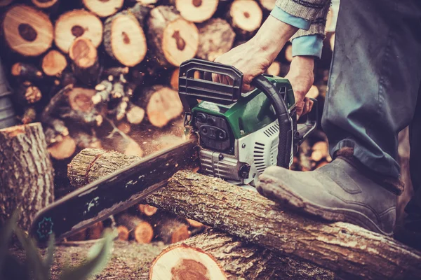 Male hands cutting trunk with chainsaw — Stock Photo, Image
