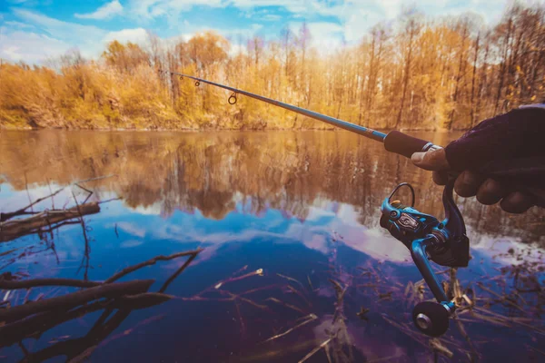 Mano con filatura e mulinello sul lago estivo serale — Foto Stock