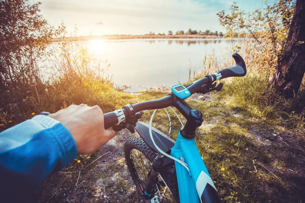 Hombre montando en bicicleta cerca del lago — Foto de Stock