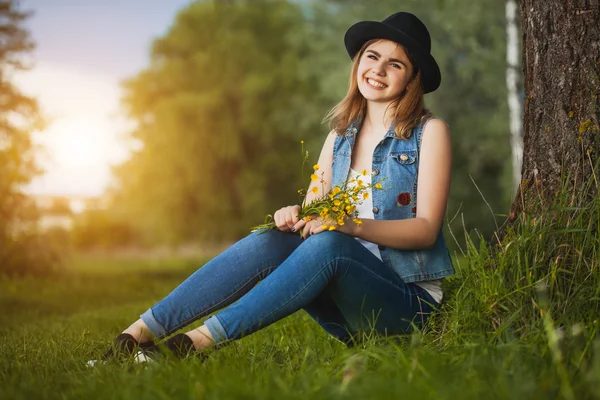 Mladá dívka v parku s květy — Stock fotografie