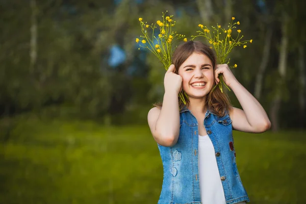 Młoda dziewczyna w parku z kwiatami — Zdjęcie stockowe