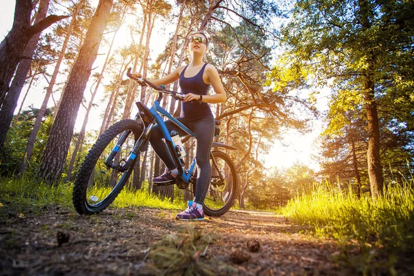 Woman cyclist rides in the forest on a mountain bike. — Stock Photo, Image