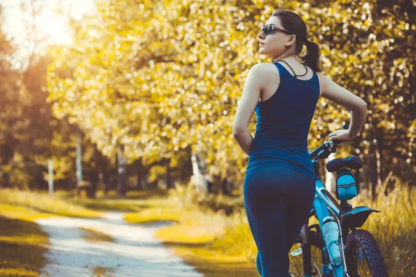 woman cyclist rides in the forest on a mountain bike.