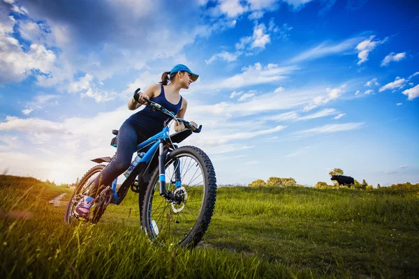 骑单车的女子在森林里骑一辆山地自行车. — 图库照片