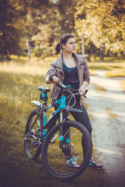 Mulher ciclista passeios na floresta em uma bicicleta de montanha . — Fotografia de Stock