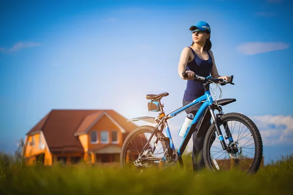 Young woman on bike in the field — Stock Photo, Image
