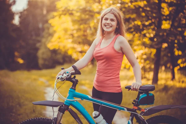 Kadın bisikletçi ormanda bir dağ bisikleti sürmek.. — Stok fotoğraf