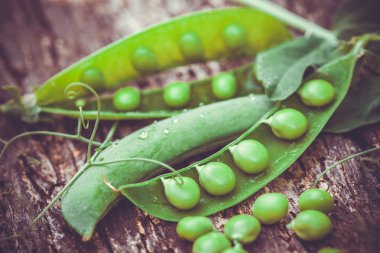 Kahverengi ahşap zemin üzerinde yeşil bezelyeler.