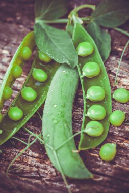 Kahverengi ahşap zemin üzerinde yeşil bezelyeler.