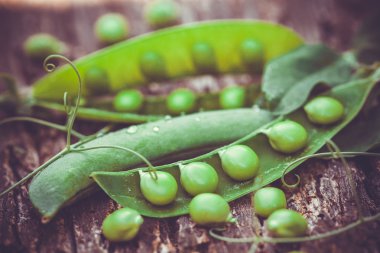 Kahverengi ahşap zemin üzerinde yeşil bezelyeler.