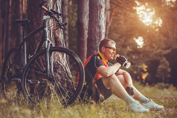 Homem ciclista passeios na floresta em uma bicicleta de montanha . — Fotografia de Stock