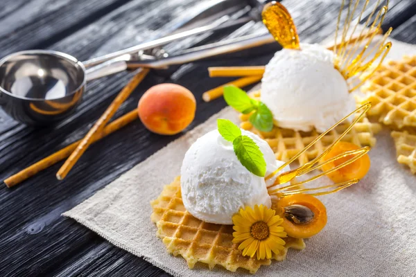 Мороженое с абрикосом, мятой и вафлями. Домашний продукт. На деревянном столе . — стоковое фото