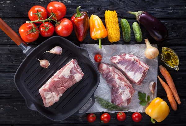 Carne de cerdo cruda en la parrilla de hueso. sobre la mesa de madera negra — Foto de Stock