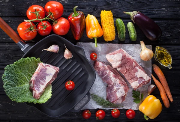 Carne de cerdo cruda en la parrilla de hueso. sobre la mesa de madera negra — Foto de Stock