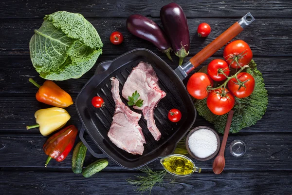 Carne de cerdo cruda en la parrilla de hueso. sobre la mesa de madera negra — Foto de Stock