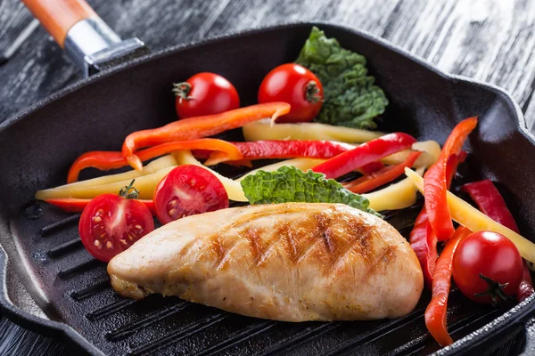 Вкусный жареный куриный филе и перец в кастрюле — стоковое фото