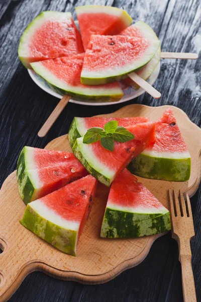 healthy watermelon on the black wooden background.