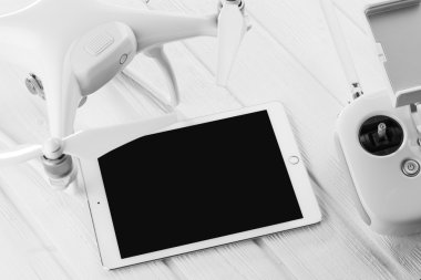 quadrocopter, tablet ve Beyaz ahşap zemin üzerinde Uzaktan kumanda