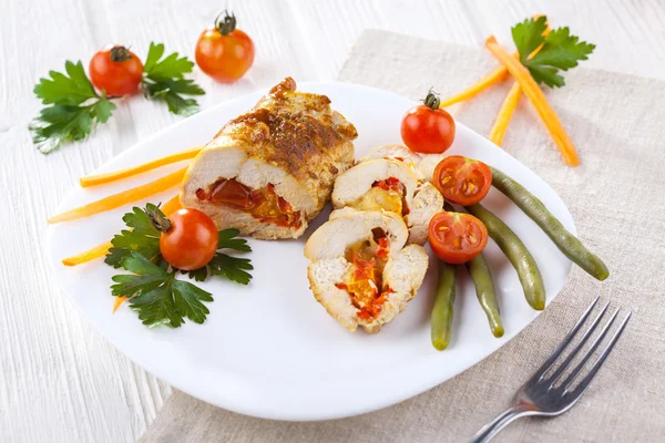 Куриные рулеты с помидорами и паприкой на белой тарелке — стоковое фото