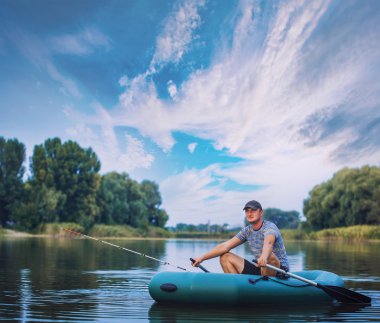 gölet üzerinde lastik tekneden balık adam