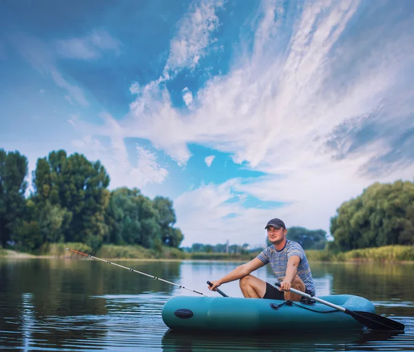 Man fishing from the rubber boat on the pond — Stock Photo, Image