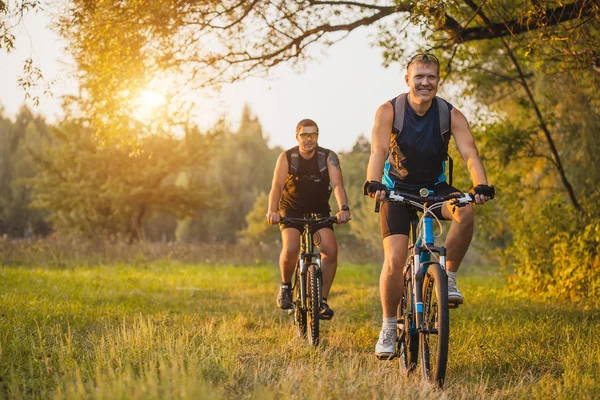 Two mountain bikers riding bike in the forest — Stock Photo, Image