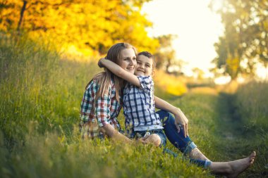 Anne ve oğlu yeşil bir çayırda oynuyorlar. Parkta aktif yürüyüş