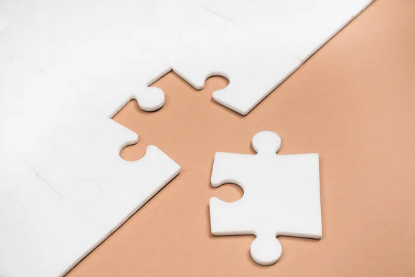 Weißes Puzzle Auf Dem Braunen Papierhintergrund — Stockfoto