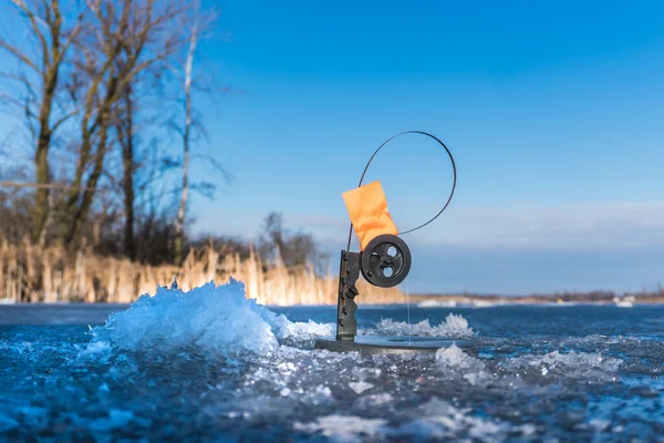 Winter fishing rod, tip-up with reel and orange flag tackle. — Stock Photo, Image