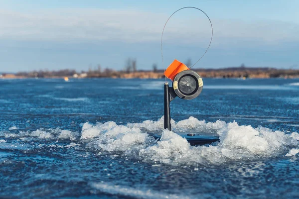 Haste de pesca de inverno, tip-up com carretel e bandeira laranja atacar. — Fotografia de Stock