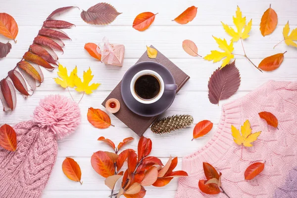 Livre, une tasse de café et un chapeau tricoté chaud, sur une table blanche en bois d'automne — Photo
