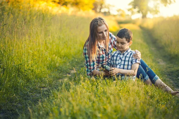 Glückliche Mutter und Sohn spielen auf einer sommergrünen Wiese — Stockfoto